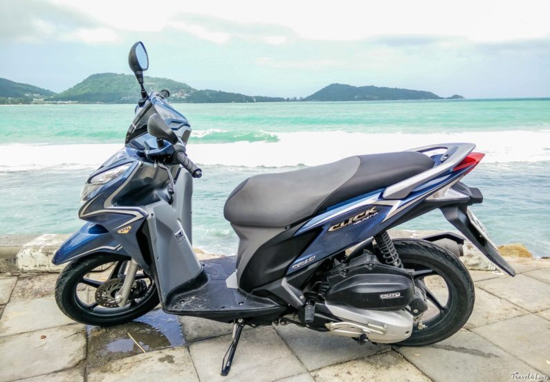 Синий скутер Honda Click на набережной у бирюзового моря