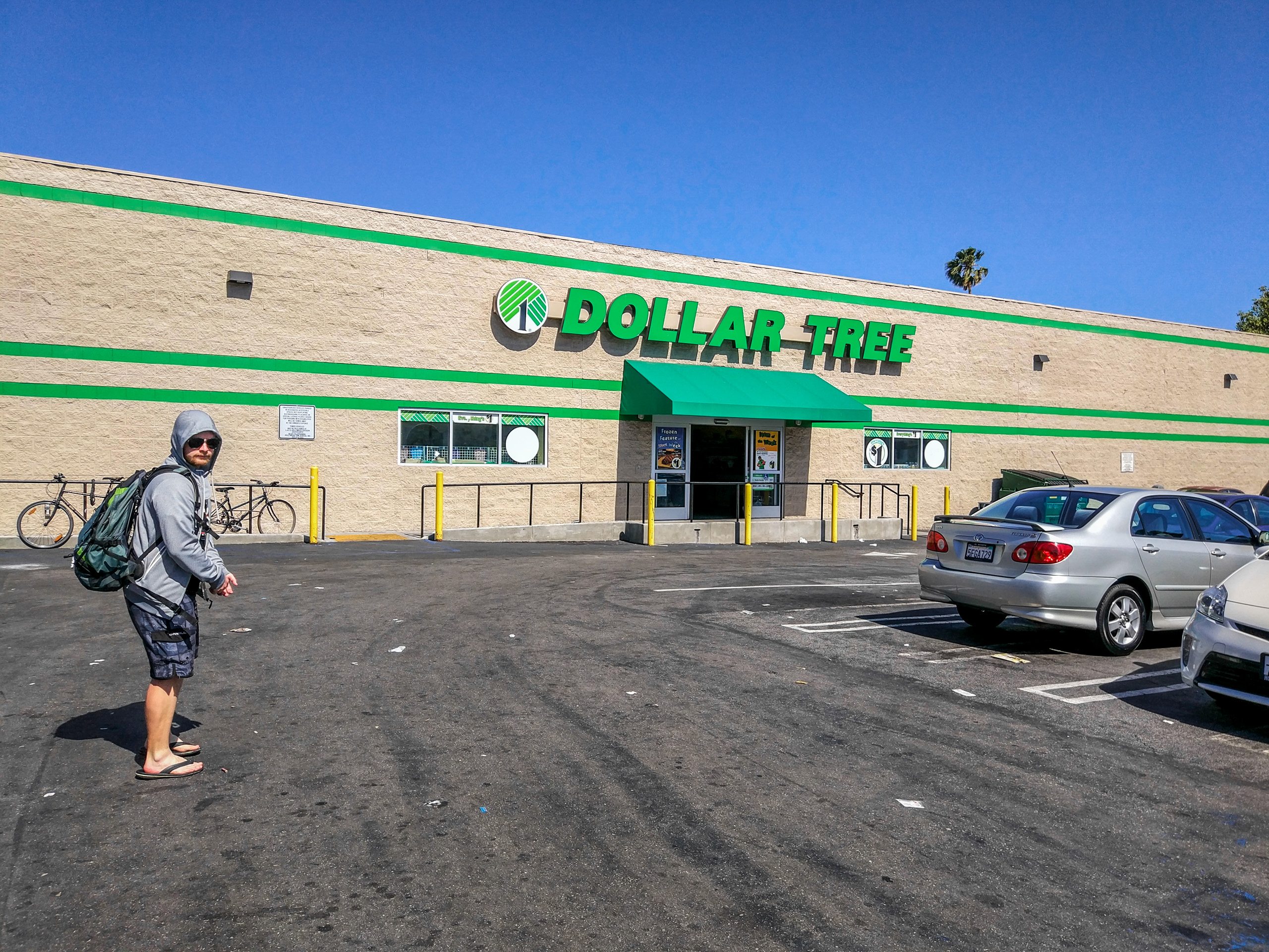 Мужчина с рюкзаком на парковке у магазина Dollar Tree, США