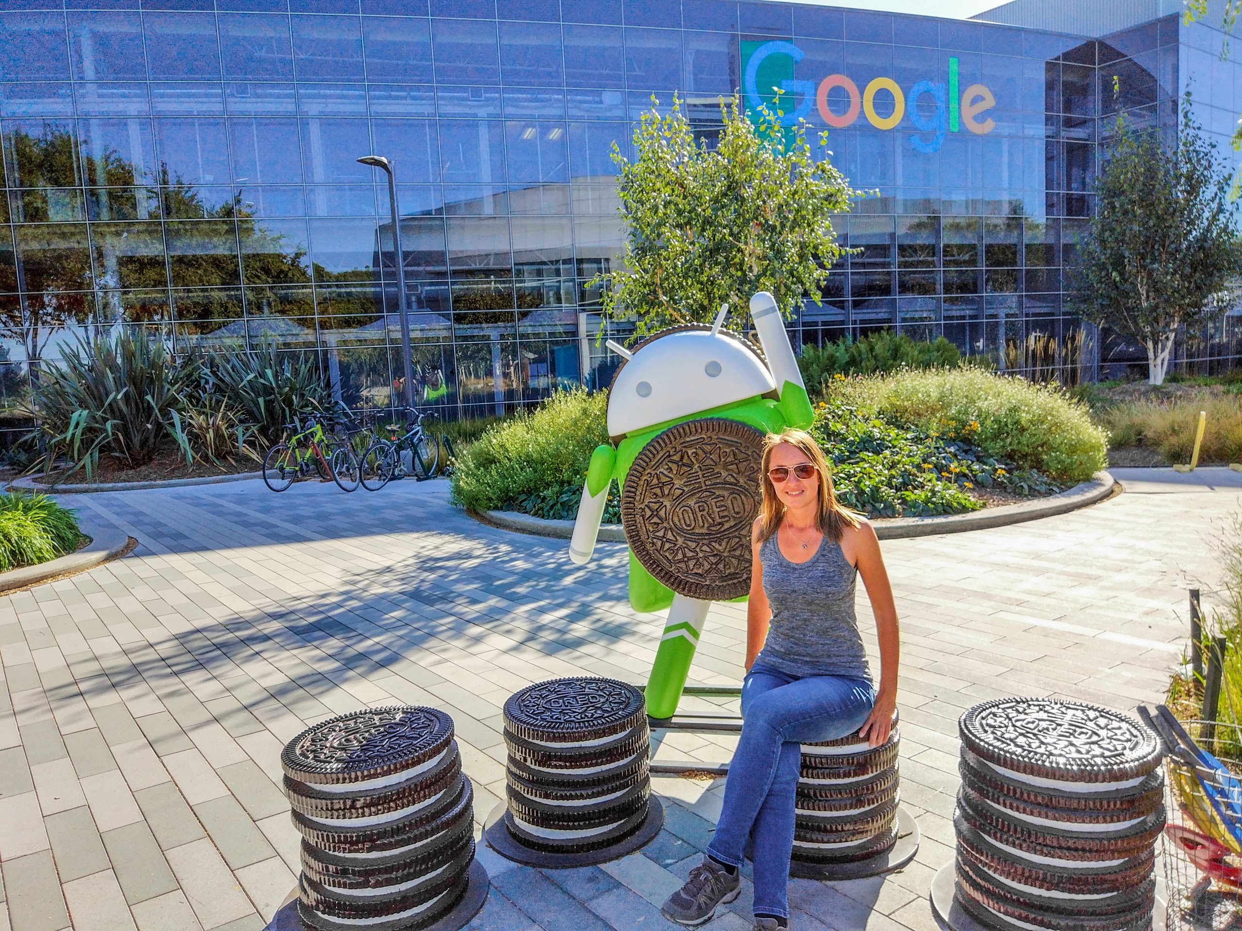 Женщина на печенье Oreo рядом со скульптурой Android перед зданием Google