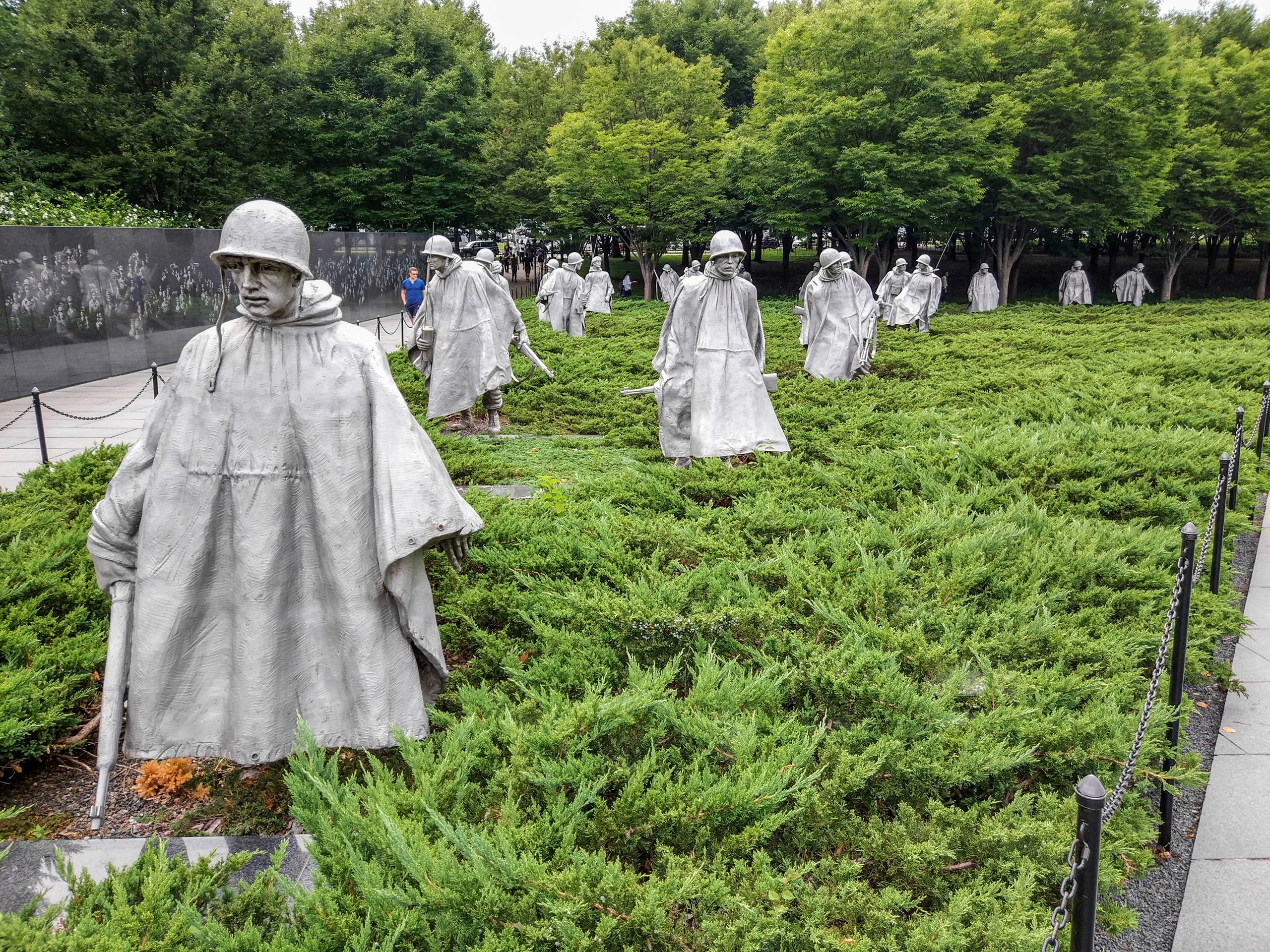 Скульптуры солдат в плащах среди можжевельника в Мемориале ветеранов Корейской войны