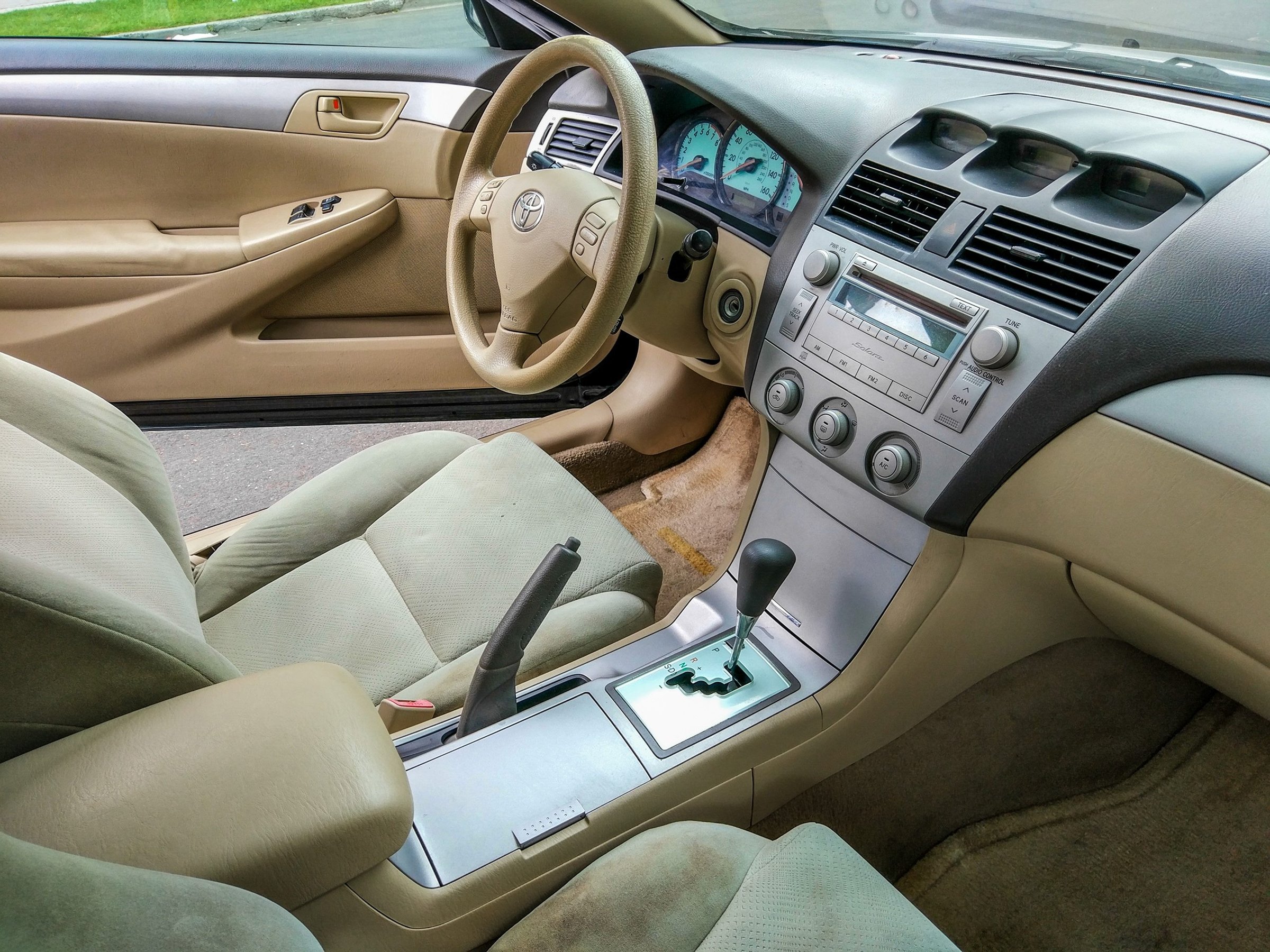 Бежевый салон Toyota Solara: руль, панель и передние сиденья